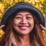 Mujer con sombre azul de mezclilla sonríe hacia la camara