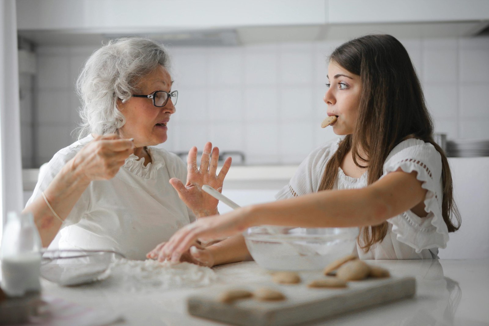 Abuela y adolescente cocinando galletas en casa, para su emprendimiento como experiencia de aprendizaje en familia y educación alternativa