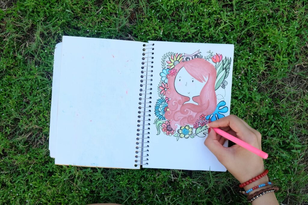 talleres educativos para adolescentes y proyecto de arte en caricatura, dibujado sobre cuaderno de hojas blancas, colocado sobre pasto verde